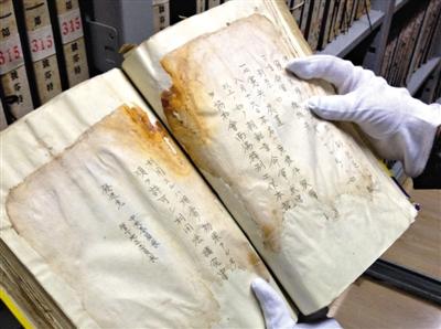 　4月30日，吉林省档案馆库房内，赵玉洁展示一册档案，库房内恒温恒湿，每天都会有例行的安全检查。新京报记者 卢美慧 摄