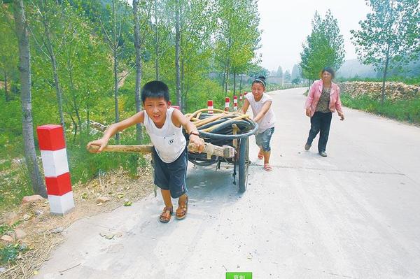 图为大人晚上睡在提灌站旁，小孩拉着板车运水管…… 　　图片来源：大河网