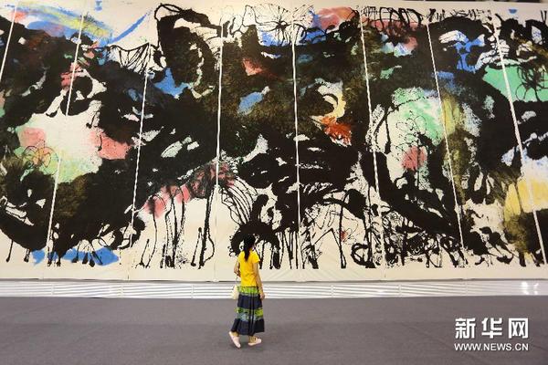 8月18日，一名观众观看崔自默创作的巨幅国画《大好荷山》。