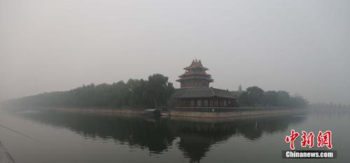 10月10日，北京故宫角楼被雾霾笼罩，与蓝天白天映衬下的故宫角楼形成了鲜明的对比。 中新社发 郭俊锋 摄
