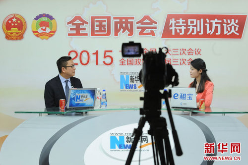 2015年3月10日，全国政协委员、香港中华厂商会永远名誉会长、恒通资源集团有限公司执行董事施荣怀做客新华会客厅。图为施荣怀与主持人交谈。新华网 贾振 摄