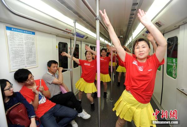 5月10日，武汉地铁2号线内，一群大妈身着舞裙，随着音乐节拍大秀舞姿，引来乘客们阵阵掌声。中新社发 亮亮 摄