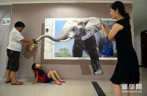 8月25日，家长带着孩子在画展上拍照留念。