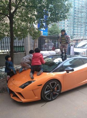 图为2014年在网上流传的兰博基尼被虐照。这辆兰博基尼停在路边,一个“熊孩子”站在车顶,引擎盖上也趴着两个。这是一辆 2011 款的 Gallardo,车已停产,售价在400万左右。
