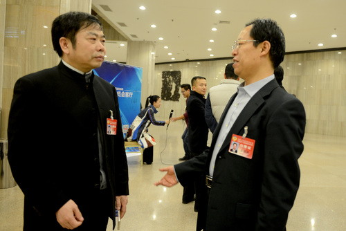 王报换和陈进林（左）在会场外交流。