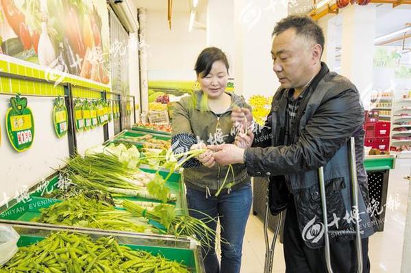 邵付香认真地教小张怎样整理蔬菜，她的店内招聘了多名像小张一样的残疾人。