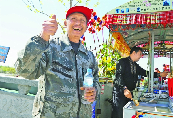 4月9日，一位老人在努尔买买提的摊位上领到免费矿泉水。
