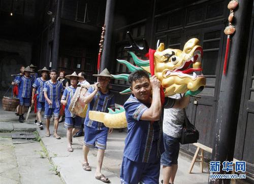 6月8日，上饶市信州区汪家园村的畬族村民表演赛龙舟前的“打官山”民俗。当日，江西省上饶市举行端午民俗展演活动，包括包粽子、发香包、“打官山”等内容，吸引不少市民参加。 新华社发（夏内信 摄）