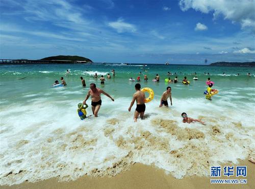 6月8日，在海南省三亚市亚龙湾海滩，人们提前“洗龙水”，迎接即将到来的端午节。 “洗龙水”是端午节期间海南最有地方特色的古老习俗，每年农历五月初五端午节当天，海南人在海滩上“洗龙水”，祈求健康、平安。新华社发（沙晓峰 摄）