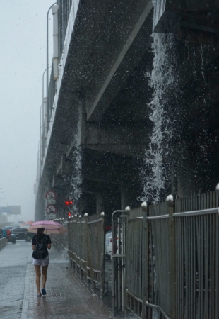 新华社照片，北京，2016年7月20日
    北京发布暴雨橙色预警
    7月20日，行人在北京五环辅路冒雨前行。
    当日11时30分，北京市气象台发布暴雨橙色预警，目前城区及南部地区6小时累计降水量达70毫米左右，局地超过100毫米，预计至20日傍晚强降水持续。
    新华社记者 李欣 摄