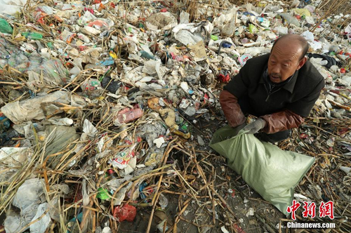 近日，上海崇明区东风西沙水库附近江面出现了大量来自外省市的生活垃圾。12月23日早间，中新网记者在上海崇明东风西沙水库岸边发现，这些垃圾正在被清理装袋，并伴有刺鼻气味。图为被冲上岸的生活垃圾五颜六色，种类繁杂。 张亨伟 摄
