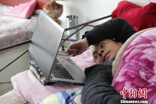 都海成用铅笔在电脑上打字。　张海雯 摄