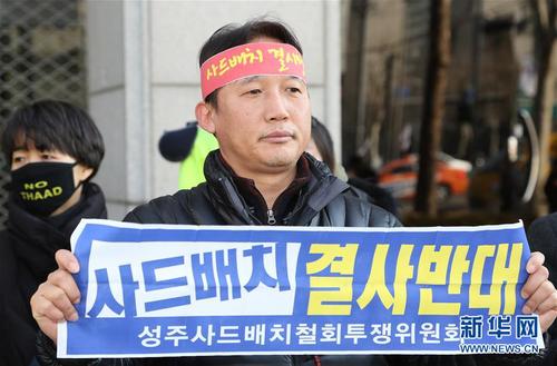 4　2月27日，一名男子在位于首尔的乐天集团总部前参加抗议示威活动，并高举反对部署“萨德”的标语。