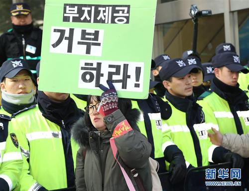 22月27日，一名女子在位于首尔的乐天集团总部前参加抗议示威活动，并高举反对乐天出让“萨德”用地的标语。