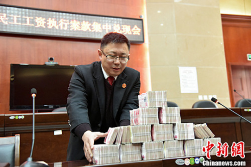 北川法院为农民工讨薪 145万工资集中兑付。图为执法人员正在清点成捆的钞票。<a target='_blank' href='http://www.chinanews.com/'>中新社</a>记者 杨勇 摄