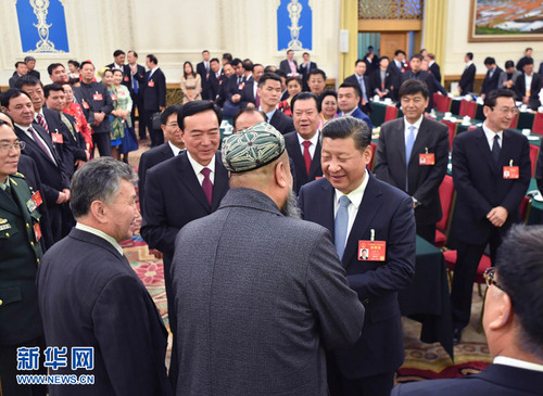 3月10日，中共中央总书记、国家主席、中央军委主席习近平参加十二届全国人大五次会议新疆代表团的审议。这是习近平同代表亲切交谈。新华社记者 李涛 摄
