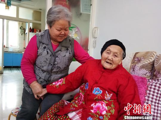 金芳准备带母亲金连玲到外面晒晒太阳。　李艳青 摄