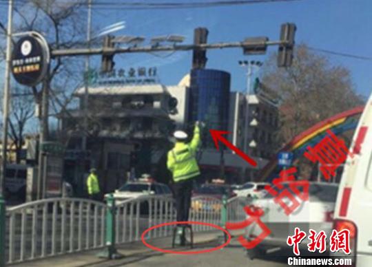 河北交警手举线缆保通行照片走红网络被赞“最帅交警”