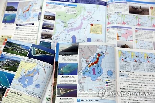 资料图片：去年日方审定通过教科书。书中写道“竹岛是日本固有领土，但非法占岛的韩国声称拥有其主权。”。（图片来源：韩联社）