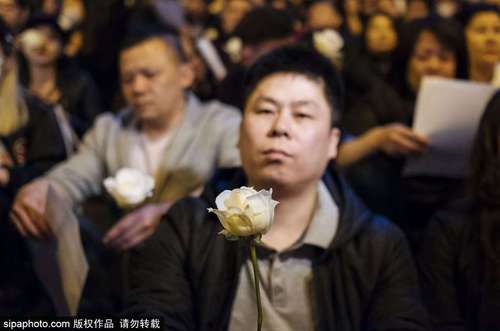 图为在参与集会抗议的人群中一位表情严肃的华人。 图片来源：sipa