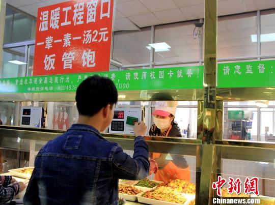 一名贫困生在温暖工程窗口刷卡。　王宇 摄