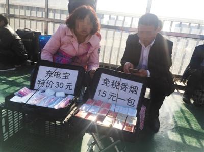 4月25日,北京站,站前广场东侧的过街天桥,两个商贩一个兜售劣质充电宝一个兜售假烟。新京报记者 王飞 摄 4月25日,北京站,站前广场东侧的过街天桥,两个商贩一个兜售劣质充电宝一个兜售假烟。新京报记者 王飞 摄