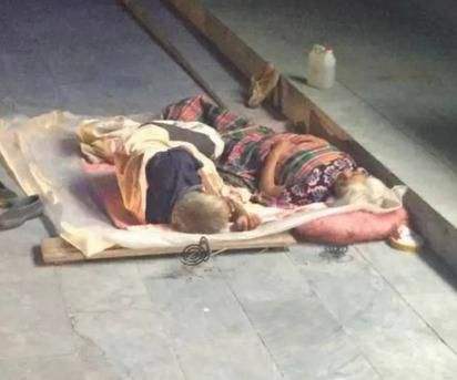 老人过道打地铺被车碾