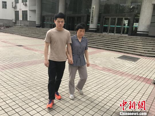 吴步晨牵着母亲走在校园。　唐小晴 摄