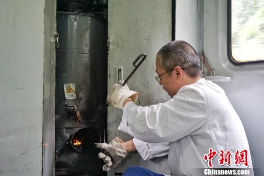 图为烧水工为确保旅客用水，定时定期检查锅炉和水箱水温水位。　包亮 摄