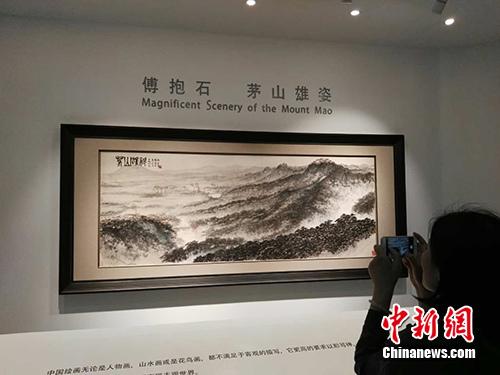拍卖预展时，观者在《茅山雄姿》画作前拍照。中新网记者 宋宇晟 摄