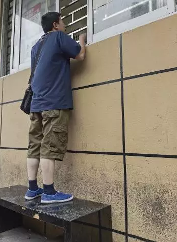 杭州闹市惊现奇葩服务窗口 办事必须爬凳子