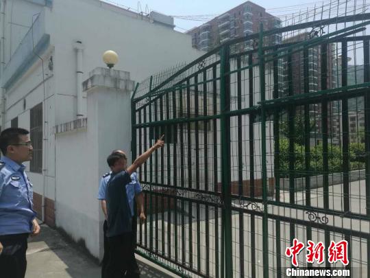 民警在护栏前将翻墙的罗某抓获。　警方 摄