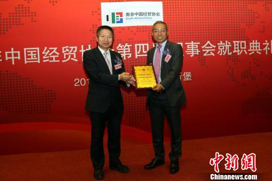 中国驻南非使馆经商参赞荣延松(左)为张进国颁发会长证书。　宋方灿 摄