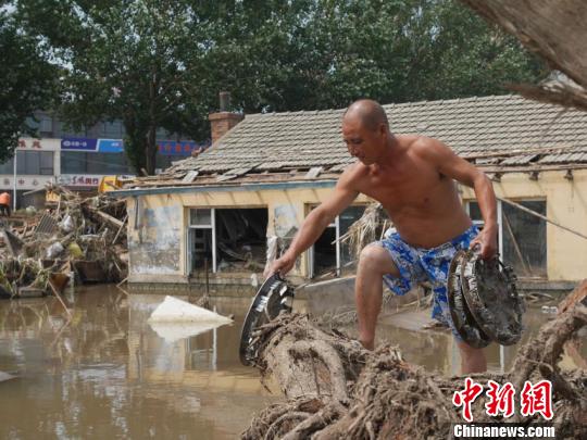 洪水退去，村民返回家中整理物品。　苍雁 摄