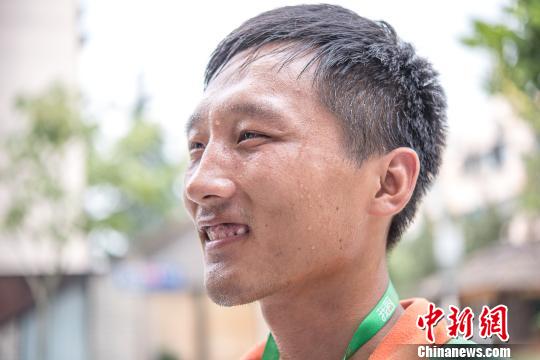 即使被晒得皮肤黝黑满头大汗，“配送小哥”仍微笑着坚持。　王子涛 摄