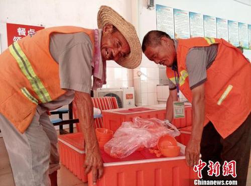 吃完“免费午餐”，大爷们愉快地自发收拾餐具。　朱志庚 摄