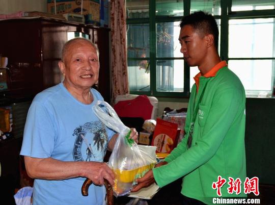 工作人员向困难老人送上“爱心食物包”。　王子涛 摄