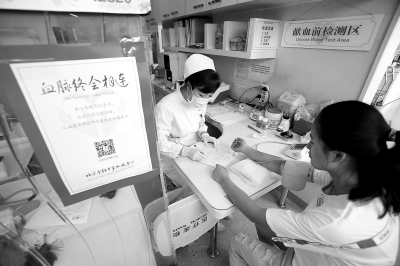 昨天，西单献血小屋内，一名前来无偿献血的女子正在接受化验。这里平常日均献血人数有20至30人，暑期以来，每天降至10至15人。 实习记者 武亦彬摄