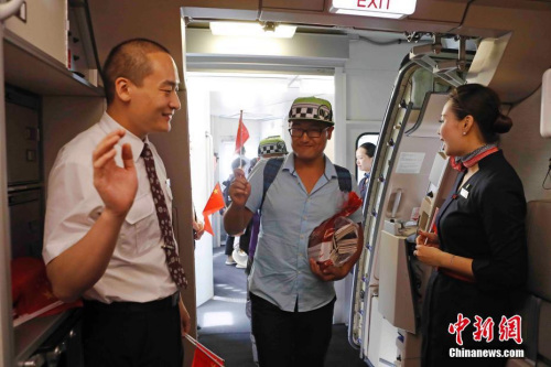 东航MU599航班乘务员在机舱门口欢迎中国同胞的到来。殷立勤 摄