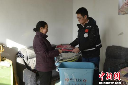 工作人员为受灾群众送物资。　王小军 摄