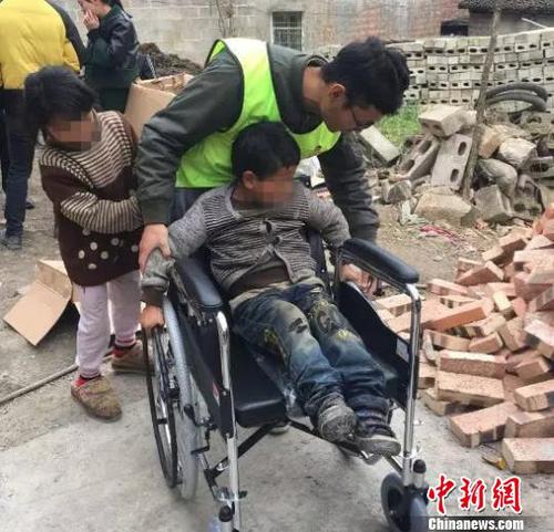 图为志愿者给周定富送来了轮椅。　钟欣 摄