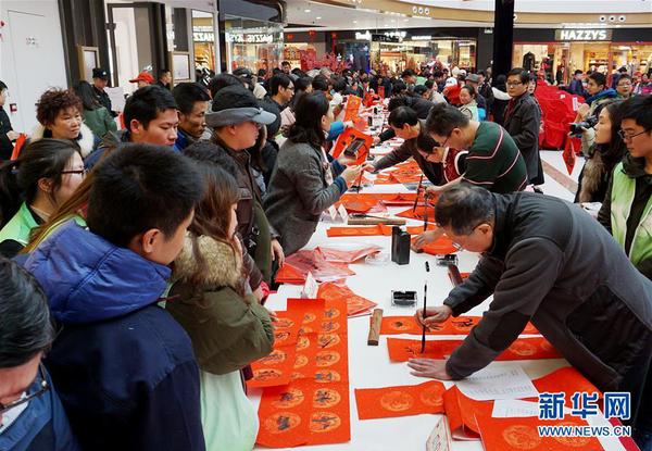2月6日，书法爱好者在活动现场书写春联，吸引众多市民观看。