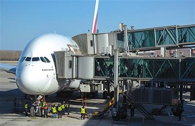 2月7日，一架飞机到达后，首都机场博维公司工作人员操作客梯廊桥与飞机连接后下客。图片来源：新京报