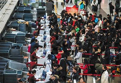 2月8日凌晨5时，首都机场T3，办托运手续的旅客已经排起长队。图片来源：新京报