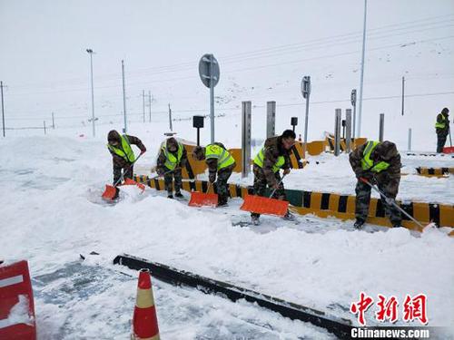 吐尔洪收费站员工清理车道积雪。　张璐璐 摄