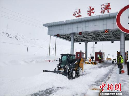 吐尔洪收费站职工清扫车道积雪。　张璐璐 摄