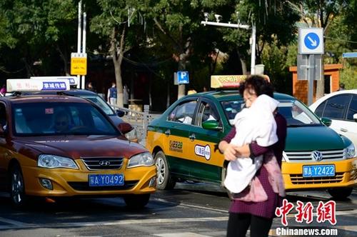 资料图:街头等红灯的出租车。<a target='_blank' href='http://www.chinanews.com/' _fcksavedurl='http://www.chinanews.com/'>中新社</a>记者 刘文华 摄