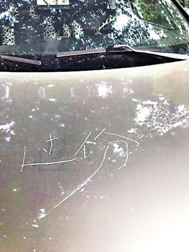 女子将车违停小区通道旁 车头遭人刻过分二字