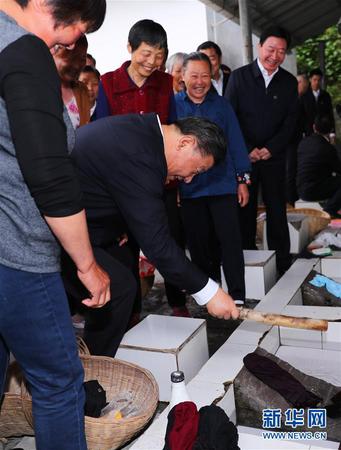　4月24日下午，中共中央总书记、国家主席、中央军委主席习近平来到紧邻三峡大坝的宜昌市夷陵区太平溪镇许家冲村，了解这个移民村的变迁和发展特色产业等情况。这是习近平接过村民洗衣用的棒槌，俯下身试着捶打了几下衣服。