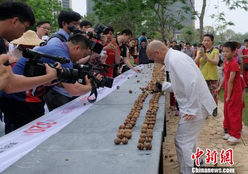 黎伟军手劈核桃现场吸引不少人围观。　程景伟 摄